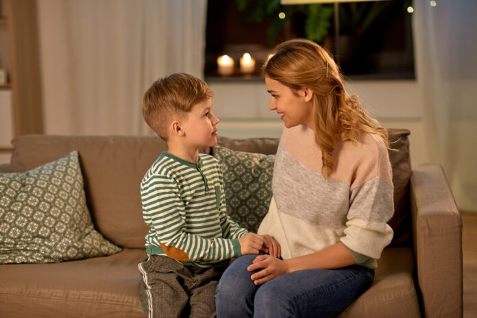 happy smiling mother talking to her son at home