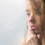 lonely girl near window thinking about something. beautiful sad
