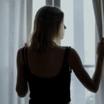 Rear view of a woman standing by the window