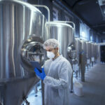 Factory worker technologist in protective uniform with hairnet a