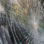 Glass broken cracks splinters in front of car . ( Filtered image