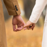 Loving couple holding hands in the forest – the concept of love