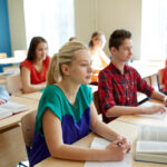 group of students with books at school lesson
