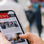 Online news on a mobile phone. Close up of businesswoman reading