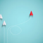 Red paper plane out of line with white paper to change disrupt a