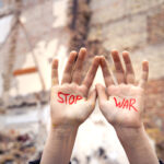 Slogan of peace without war is written on the woman’s hand in re