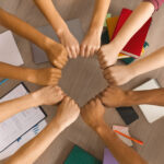 Multiracial students joining hands together in cooperation
